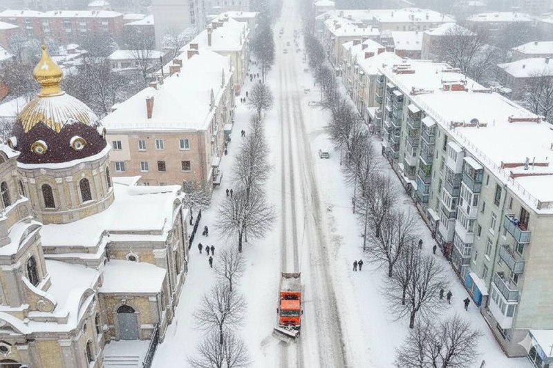 Дякуємо чи скаржимося? Що кажуть бердичівляни про прибирання снігу в місті. Після періоду сильних морозів у Бердичів прийшло потепління, а разом із ним повернулися й рясні снігопади. Лише за два дні місто помітно засипало снігом. Зранку пересування тротуарами було ускладненим, а не всі дороги встигли оперативно розчистити. Водночас варто зазначити, що основні центральні вулиці міста були прибрані ще з ночі, і транспорт там рухався без суттєвих ускладнень. У комунсервісі визнають: встигнути всюди одночасно складно. Дається взнаки нестача спеціалізованої техніки, яка могла б швидко охопити все місто, а також дефіцит працівників. Підприємство регулярно публікує оголошення про набір на роботу — вакансій справді чимало. Тим часом у соціальних мережах думки бердичівлян розділилися. Частина мешканців дякує комунальникам за роботу, інші ж скаржаться на окремі вулиці та провулки, де прибирання або запізнилося, або взагалі не проводилося. Ось лише кілька відгуків містян: Надія Садовська: «Мрії здійснюються — саме зараз Завідню розчищають від снігу. Дуже дякую за турботу!» Юлія Брижук: «Базар з вул. Миру і там, де коло було — жах 😒» Лілія Левковська: «Чистять і посипають». Олександра Пилипенкова: «По Торговій знову місиво. Не чистили». Тіна Гай: «Чистять, так, дякую». Користувач під псевдонімом Джон Картер: «Провулок Данилівський, як завжди, забули…» Комунальні служби запевняють, що роботи з прибирання снігу тривають у посиленому режимі, а першочергово очищаються центральні вулиці, маршрути громадського транспорту та під’їзди до соціально важливих об’єктів.